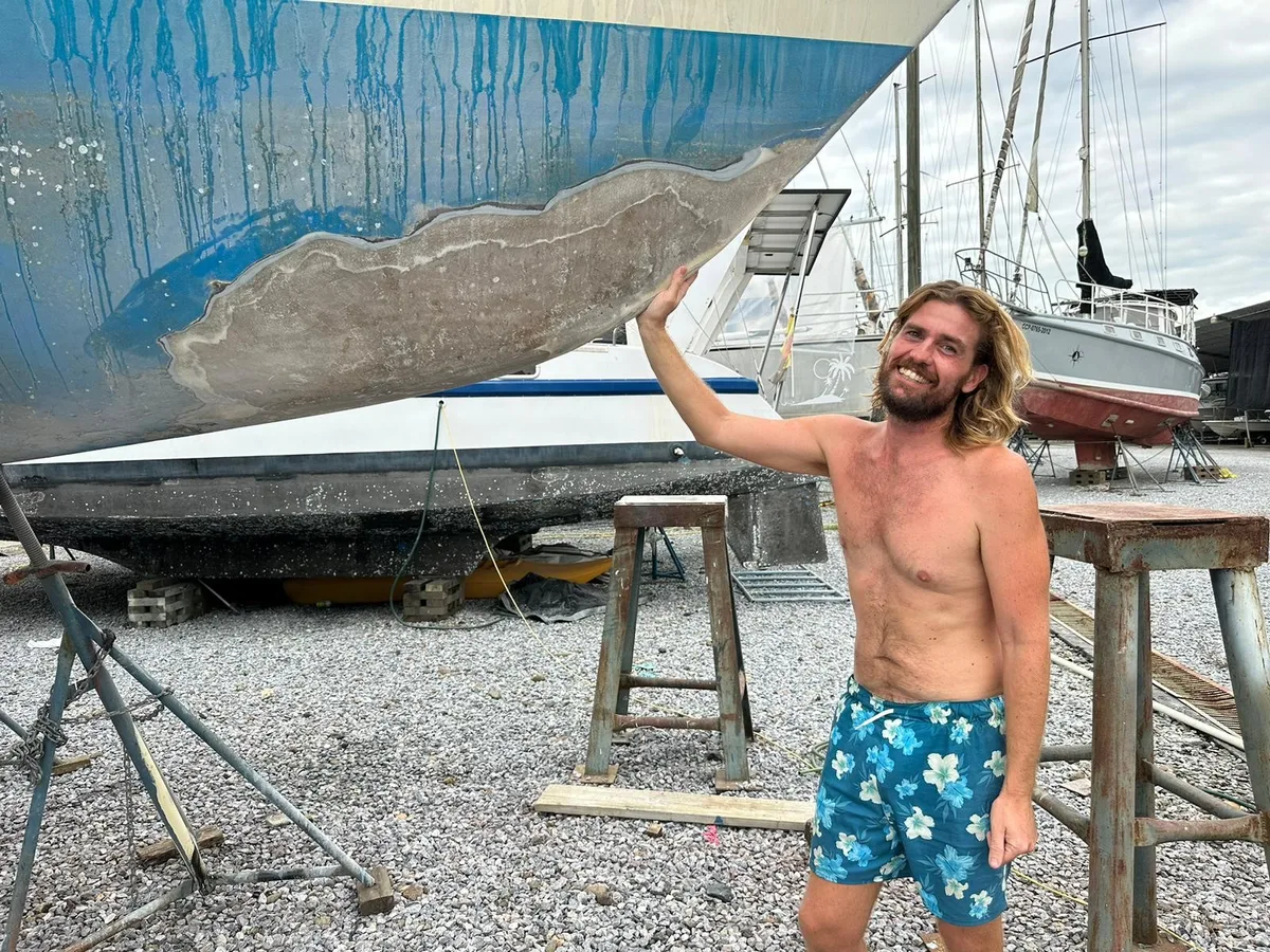 Nicolai Christiansen neben seinem lädierten Segelboot